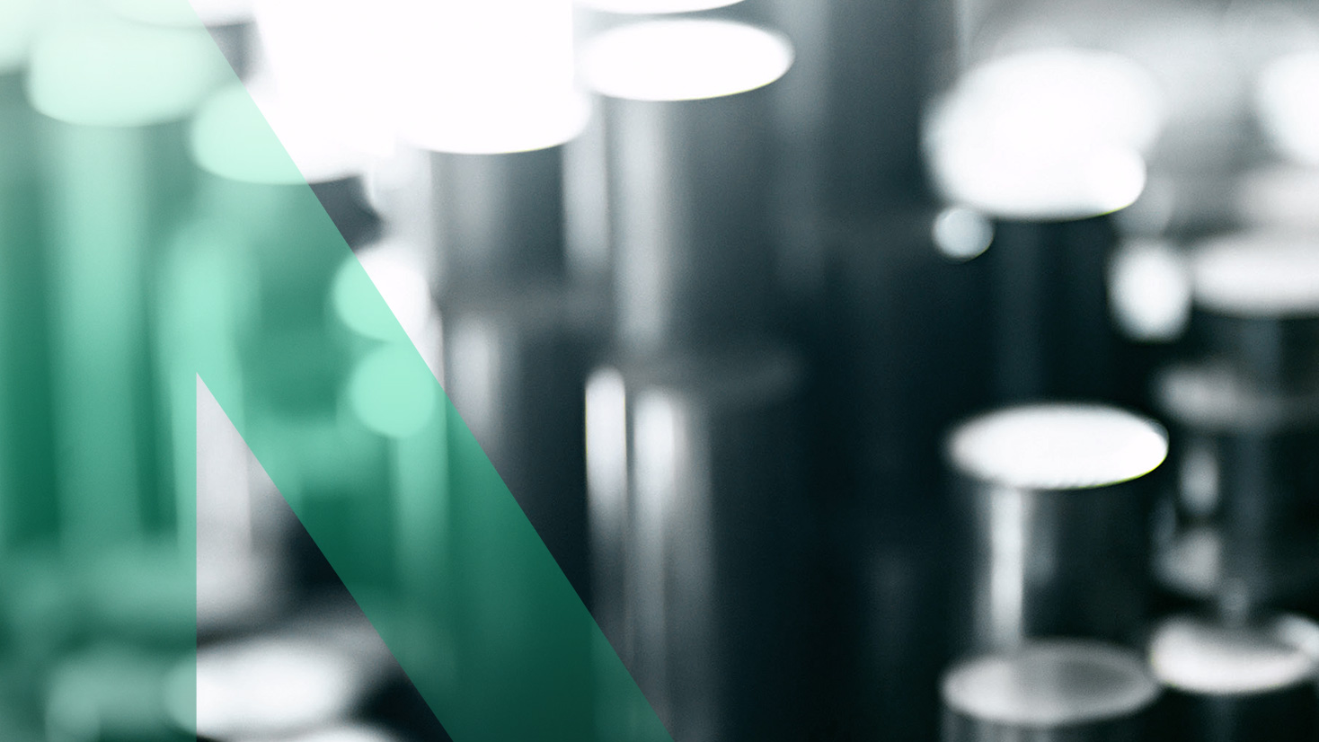 Unscharfes Bild von Metallzylindern mit einem grünen diagonalen Streifen darüber, der die Marke Nexigen symbolisiert.